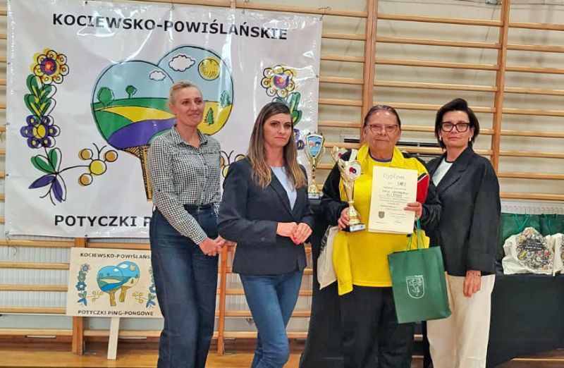Zawodnicza WTZ Ryjewo odbiera nagrodę za udział w turnieju tenisa stołowego.