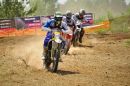 Zdjęcie ilustracyjne zawodników biorących udział w zawodach motocrossowych.