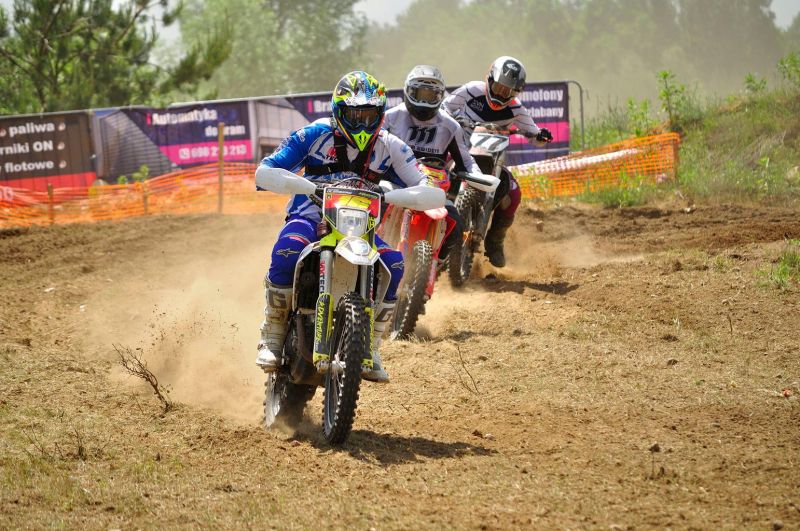 Zdjęcie ilustracyjne zawodników biorących udział w zawodach motocrossowych.