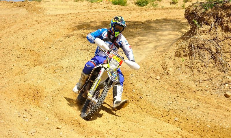 Zdjęcie ilustracyjne zawodnika biorącego udział w zawodach motocrossowych.